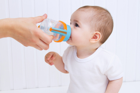 Beautiful baby drinking water from bottle